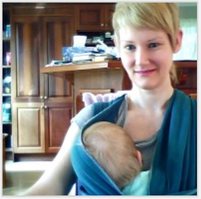 author working with baby in wrap